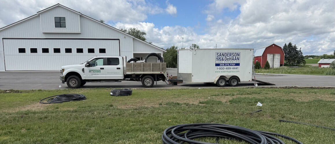 Sanderson & DeHaan irrigation truck, trailer, and installation equipment at a new sprinkler system project in Grand Rapids, Michigan.