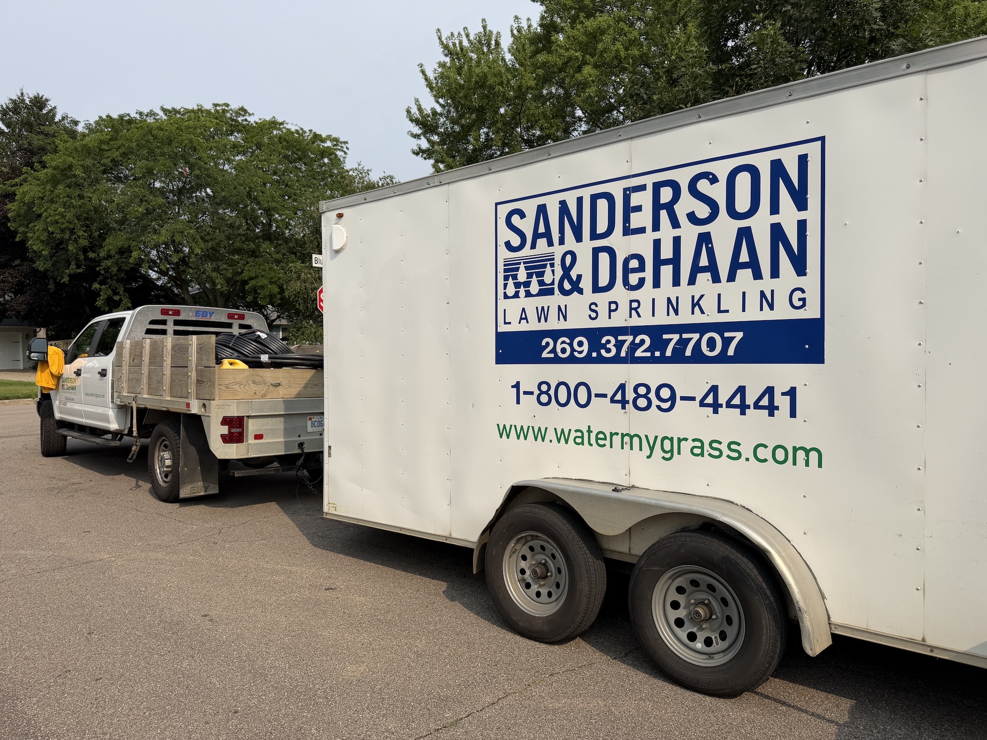 Branded Sanderson & DeHaan irrigation trailer at a sprinkler system installation in Schoolcraft
